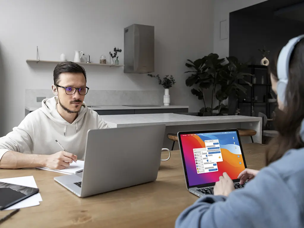 Image of 2 people working on a laptop solving a problem and discussing it.
